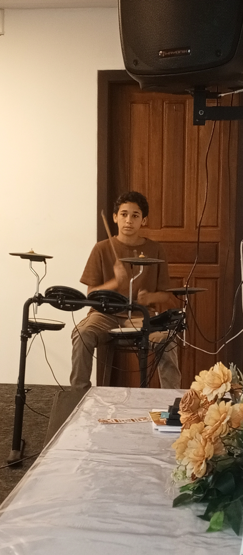 Jovem na bateria durante o Culto da Família